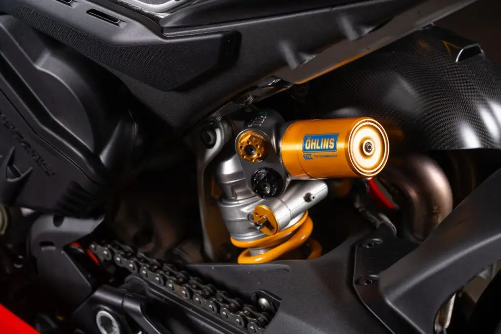 Motosiklet Karşılaştırma 2 Detailed close-up of the Öhlins suspension on a Ducati Panigale motorcycle showing intricate parts.