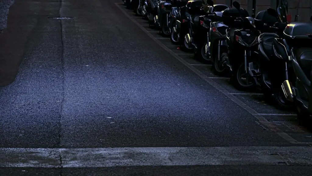 Karanlık bir sokakta yan yana park etmiş motosiklet sırası &mdash; temsili g&ouml;rsel