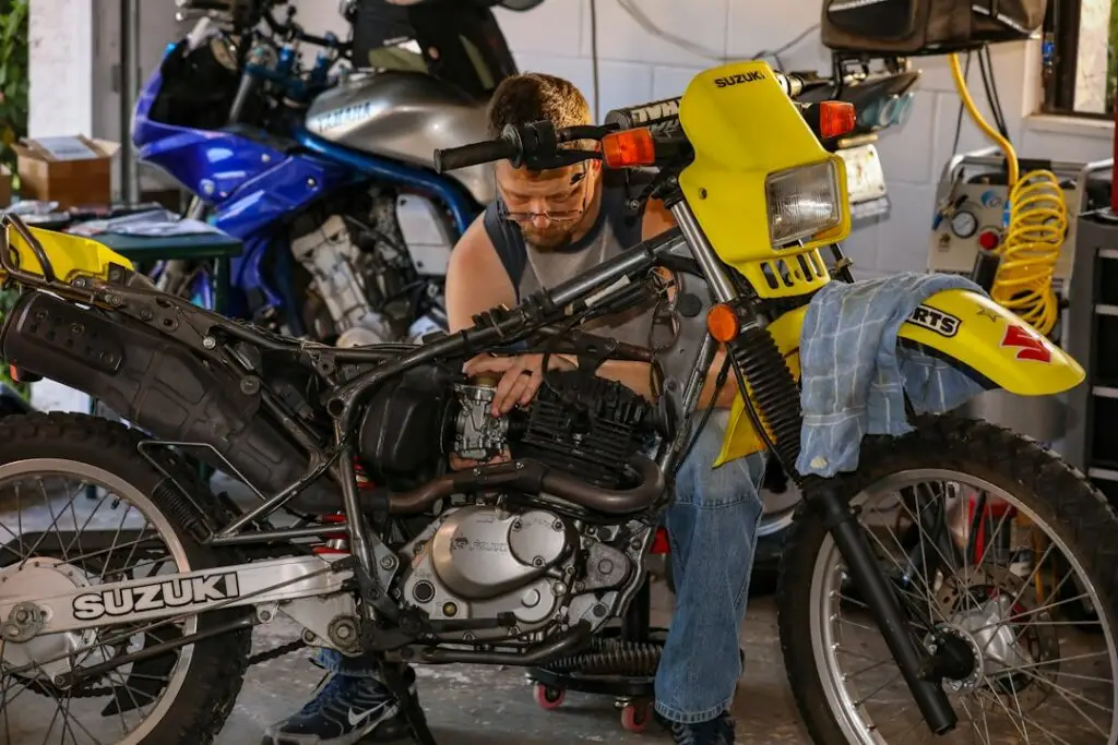 Motosiklet tamircisi at&ouml;lyede motor &uuml;zerinde &ccedil;alışıyor