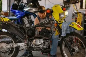 Motosiklet tamircisi atölyede motor üzerinde çalışıyor
